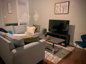 a living room with a couch and a television at 2br Hideaway just 2 miles from Beale St and Overton Square! in Memphis