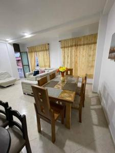 a dining room with a table and chairs and a couch at Para buenos gustos, buen confort in Tumba