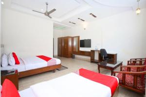 um quarto com 2 camas, uma secretária e uma televisão em OYO Nimantran Resort em Baddi