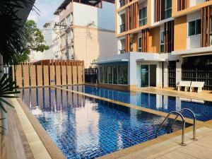a swimming pool in front of a building at 1 Double bedroom Swimming pool Apartment for Rent in UdonThani With Gym Laundry in Udon Thani
