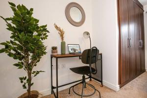 Zimmer mit einem Schreibtisch, einem Stuhl und einer Pflanze in der Unterkunft Detached House with Free Parking, Super-Fast Wifi, SmartTV and Garden by Yoko Property in Milton Keynes