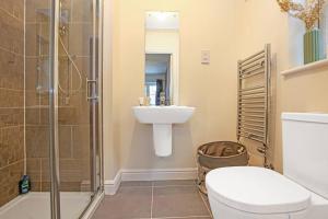 uma casa de banho com um WC, um lavatório e um chuveiro em Detached House with Free Parking, Super-Fast Wifi, SmartTV and Garden by Yoko Property em Milton Keynes