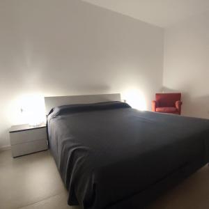 ein Schlafzimmer mit einem Bett und einem roten Stuhl in der Unterkunft BBConegliano Borlini in Conegliano
