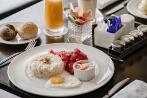 a plate of food with rice and fruit on a table at Sofitel Philippine Plaza Manila in Manila
