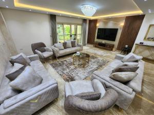 a living room with couches and a flat screen tv at شقة راقية فندقية فرش جديد عمارة فندقيه المهندسين الجيزة in Cairo