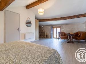 a bedroom with a bed and a table and chairs at Gîte charmant en tuffeau près de Saumur avec terrasse, poêle à bois et grandes commodités - FR-1-622-64 in Vaudelnay