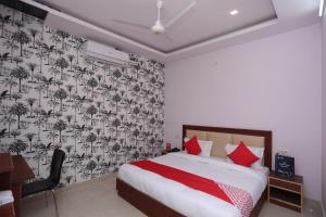 a bedroom with a bed with a black and white wallpaper at OYO Hotel Blueberry in Faridabad