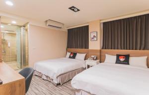 a hotel room with two beds and a shower at Royal Rose Hotel Taipei Station in Taipei