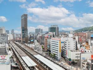 vistas a una ciudad con vías de tren y edificios en Sotetsu Fresa Inn Kobe Sannomiya en Kobe