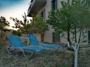 two blue chairs sitting in front of a building at VISTA DI MARE 3 in Lixouri