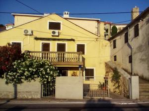 a building with a balcony on the side of a street at Apartman MICHI in Sveti Juraj