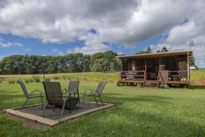 un grupo de sillas y una mesa en un campo en Blackwattle Farm en Beerwah