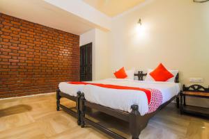 a bedroom with a bed with a brick wall at OYO La Petite Near Dabolim Airport in Chicolna