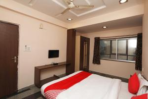 a bedroom with a bed and a tv and a window at OYO Hotel Emerald in Raipur