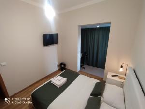 a small bedroom with a bed and a tv on the wall at MCR Barreiro - Lisboa in Lavradio