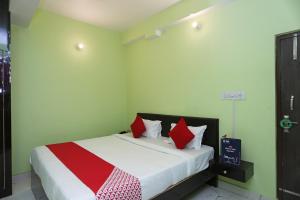 1 dormitorio con 1 cama con almohadas rojas y blancas en Flagship Near Anisabad Golambar en Patna