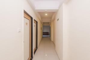 a corridor of a hospital hallway with white walls and a ceiling at Hotel Orbit Inn Near Infiniti Mall in Mumbai