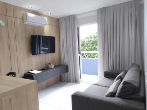 a living room with a couch and a tv at Ponta Negra Beach Flat Prime in Natal