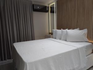 a large white bed in a hotel room at Ponta Negra Beach Flat Prime in Natal