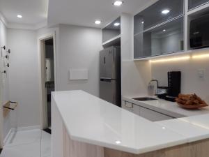 a kitchen with a white counter top and a refrigerator at Ponta Negra Beach Flat Prime in Natal