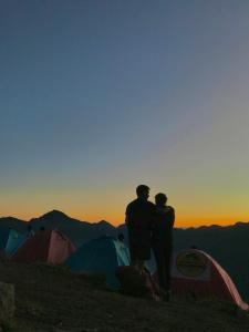 duas pessoas no topo de uma montanha com tendas em Rinjani Houseboon em Senaru