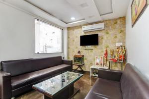 a living room with a couch and a tv at Townhouse Soni Inn in Rāipur