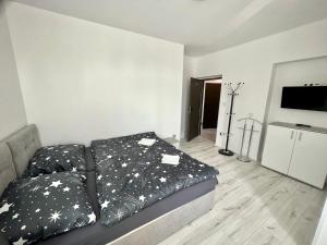 una camera da letto con un letto con cuscini bianchi e neri di Apartmány Pihel s parkovaním zdarma 