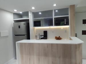 a kitchen with a white counter and a refrigerator at Ponta Negra Beach Flat Prime in Natal