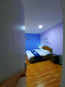 a person opening a door to a bedroom with a bed at Guesthouse of Irina in Chvabiani