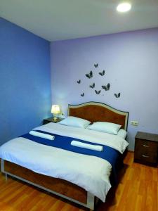 a blue bedroom with a bed with birds on the wall at Guesthouse of Irina in Chvabiani