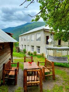 a table and chairs in a yard with a building at Guesthouse of Irina in Chvabiani