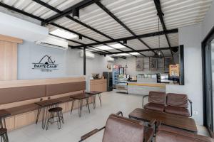 a restaurant with tables and chairs in a room at RedDoorz near Puri Indah Lippo Mall 2 in Jakarta