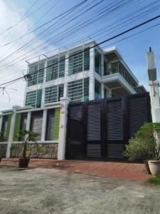 a large building with black doors and a fence at Delta Star Manor in Naga