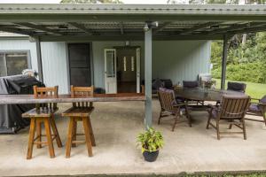 a patio with a table and chairs and a house at Blackwattle Farm in Beerwah