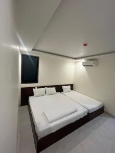 a bedroom with a bed with a tv on the wall at Khách sạn Thiên Minh - Dốc Lết in My Luong