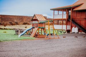 a playground with a slide next to a building at Crooked River Ranch Cabins in Terrebonne