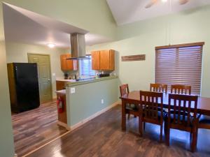 a kitchen and dining room with a table and a refrigerator at Crooked River Ranch Cabins in Terrebonne