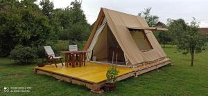 a tent on a wooden deck in a field at Na vrtu K25 in Gradac