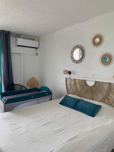 Un dormitorio con una cama con una almohada azul. en Studio Bod’Lanmè - Trois îlets, en Les Trois-Îlets