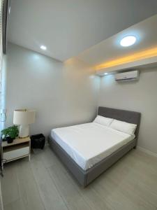 1 dormitorio con 1 cama blanca y 1 lámpara en Casa Susana - Belair en Santa Rosa