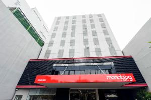 a building with a red sign in front of it at Monoloog Hotel Palembang in Palembang