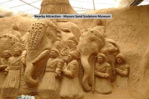 a sand sculpture of people and elephants on a wall at OYO Jk Inn in Narasimharaja Puram