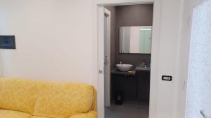 a bathroom with a yellow chair and a sink at Residenza il Gelsomino in Cantello