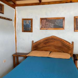 ein Schlafzimmer mit einem Bett mit einem Kopfteil aus Holz in der Unterkunft Jardin Pacifico in Canoa