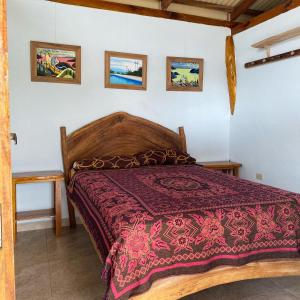 Schlafzimmer mit einem Bett mit einer roten Bettdecke in der Unterkunft Jardin Pacifico in Canoa