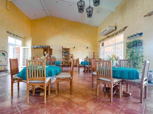 Boca Chica BnB at Gone Fishing Panama Resort في بوكاتشيكا: غرفة طعام كبيرة مع طاولات وكراسي زرقاء