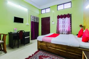 um quarto com uma cama, uma secretária e uma televisão em OYO Alohi Ghar em Bhutiāgāon