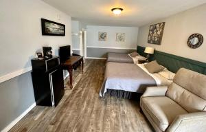 Habitación con 2 camas, sofá y escritorio. en Alaska Angler's Inn en Soldotna