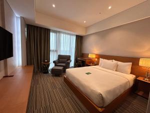 a hotel room with a bed and a chair at Hotel Tour Incheon Airport Hotel & Suites in Incheon