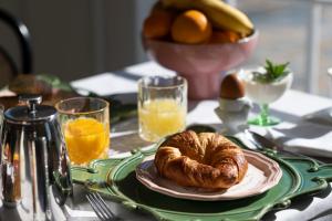 a table with a plate of bread and orange juice at Le Mas Barossa in Rowland Flat